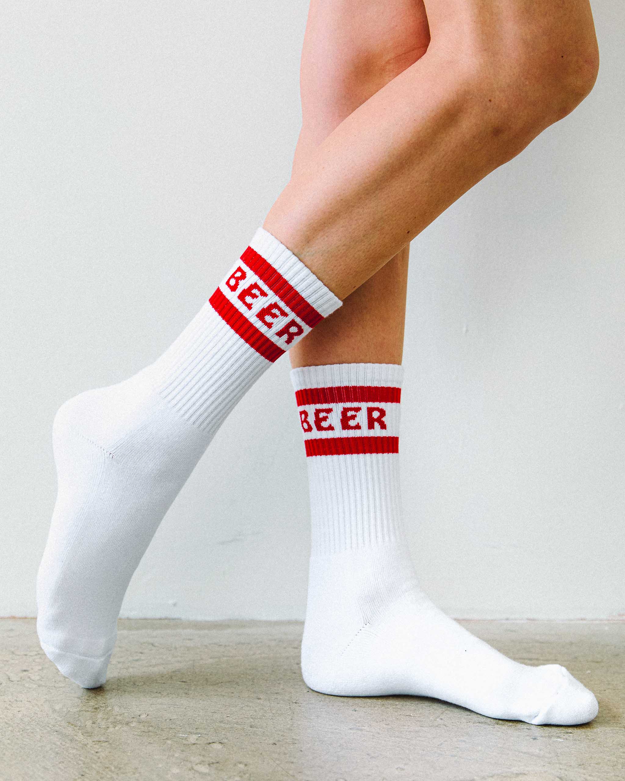 White cotton crew socks with Beer written on them in red.