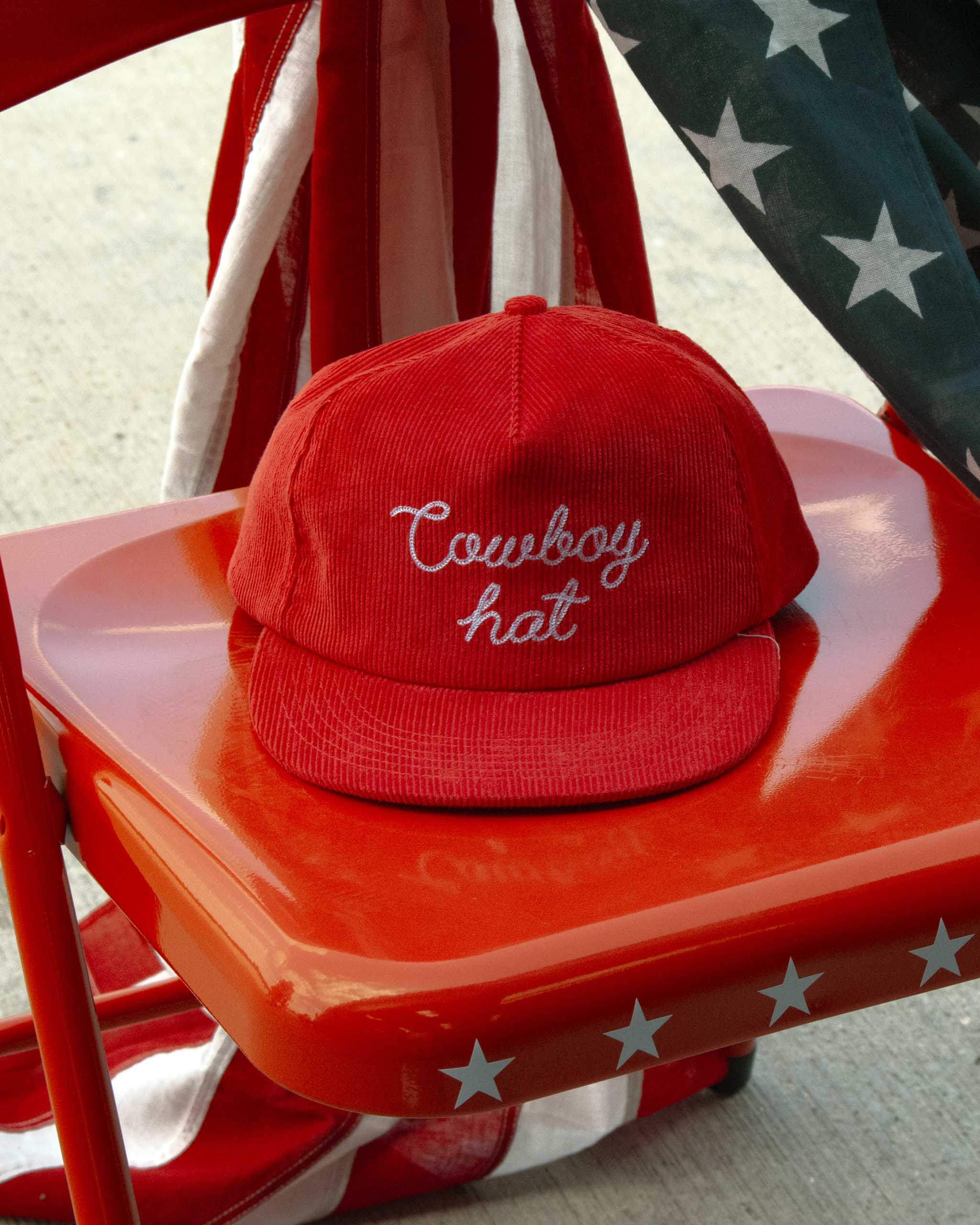 Red cap with 'Cowboy hat' text on a red chair with American flag and stars.