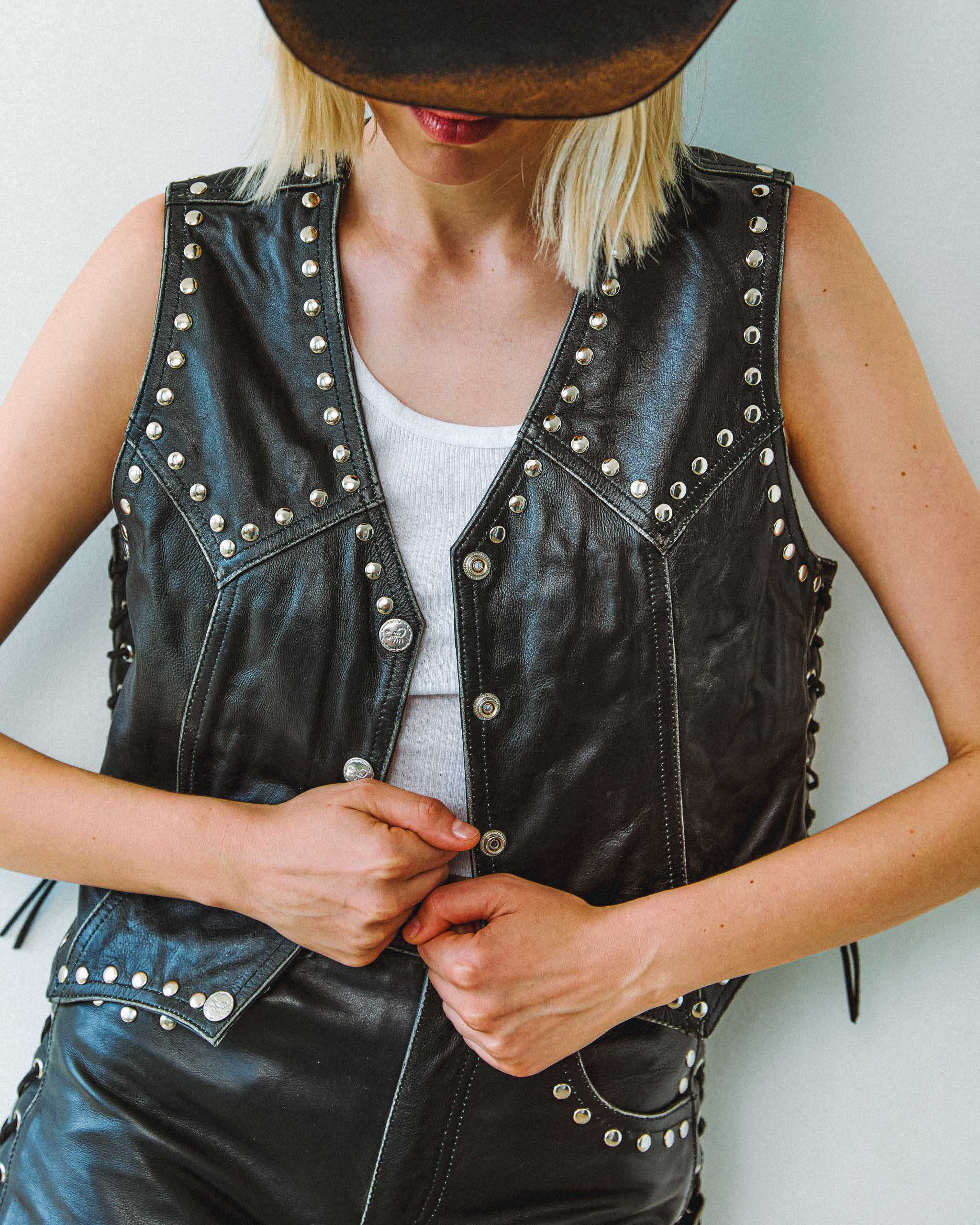 A young woman wearing the Sleazy Rider coyote studded leather vest and shorts, for bikers and cowgirls.