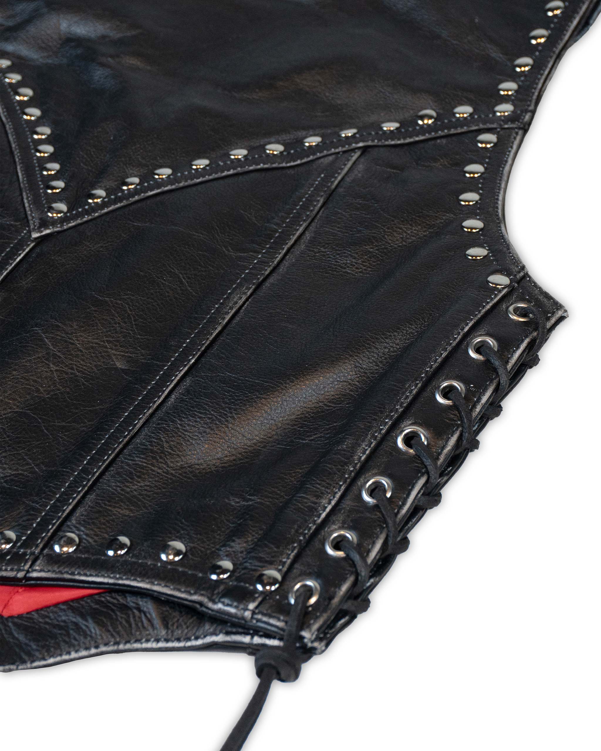 Close-up of a black studded leather vest with on a white background