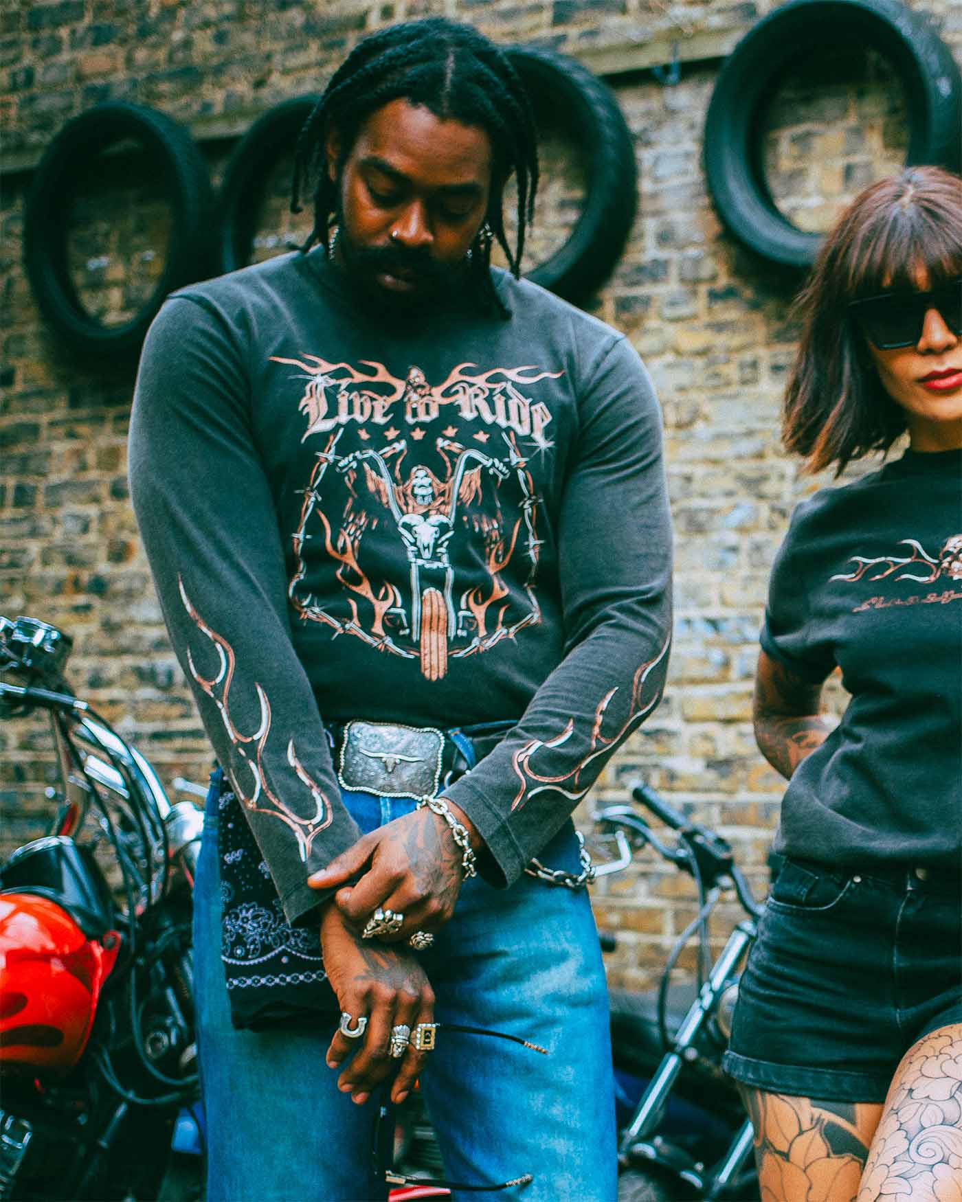 A black alternative model wearing a Sleazy Rider long sleeve t-shirt