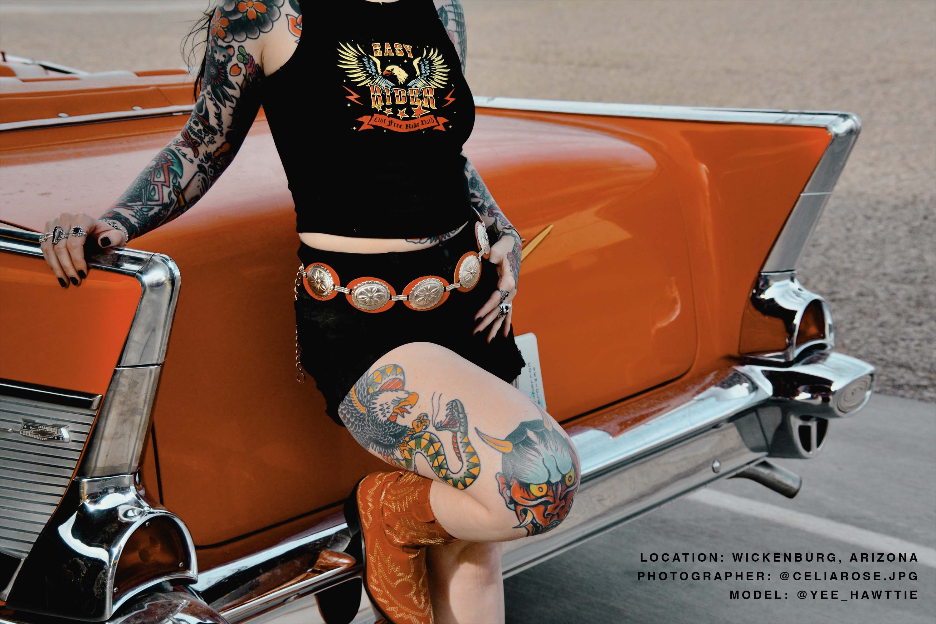 An alternative model posing next to a vintage car