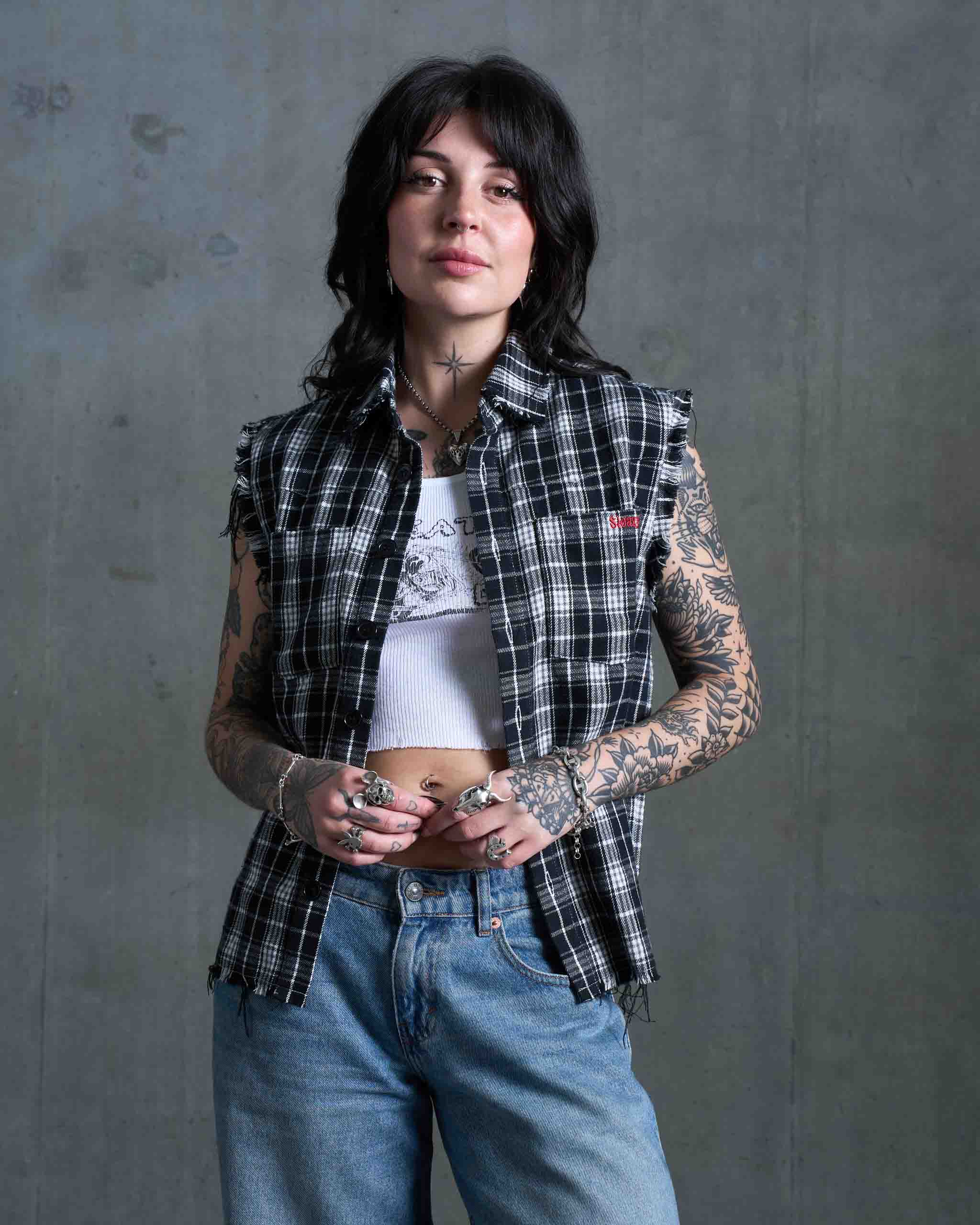 A redneck woman wearing a flannel cut off and jeans.
