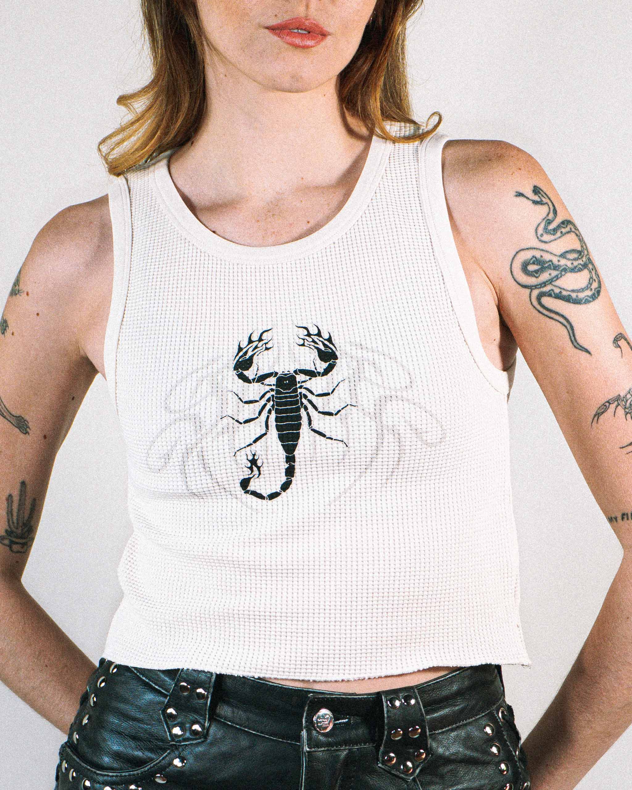 An alt model wearing an off white waffle knit top with a scorpion print.