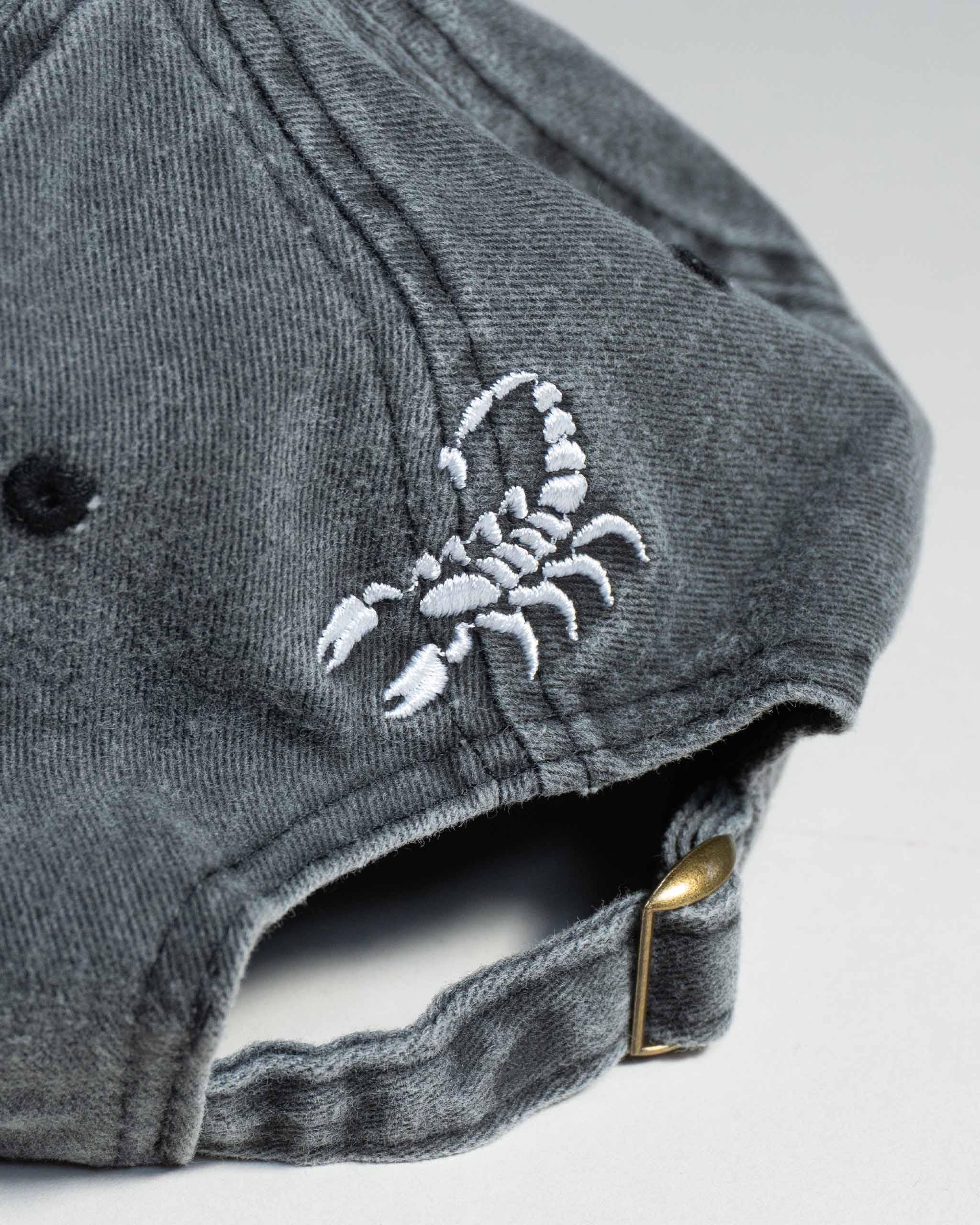 Gray Sleazy Rider cap with a white scorpion embroidery.