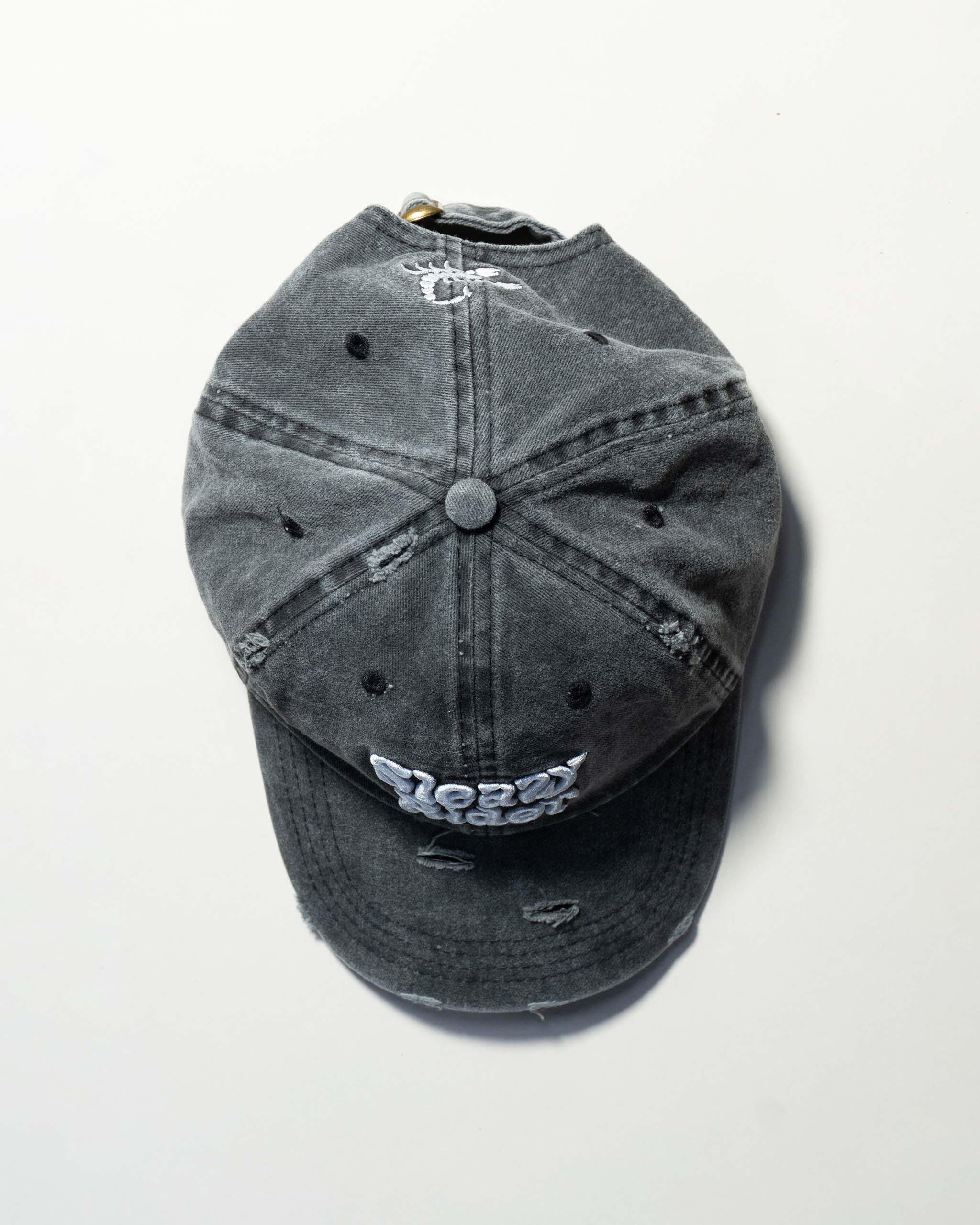 Faded black distressed baseball cap with "Sleazy Rider" text and a scorpion embroidery.