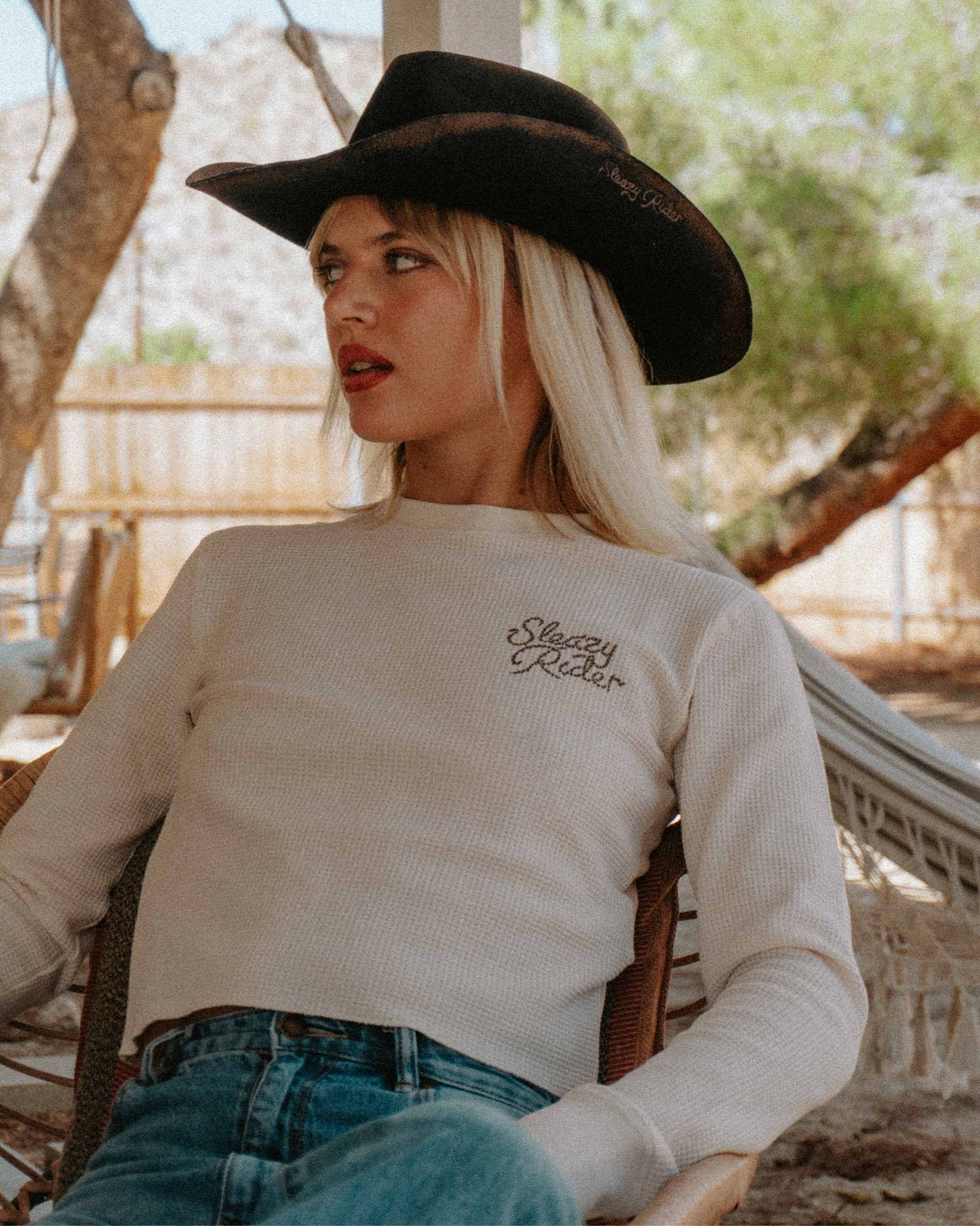 A cowgirl wearing an off white waffle knit top.
