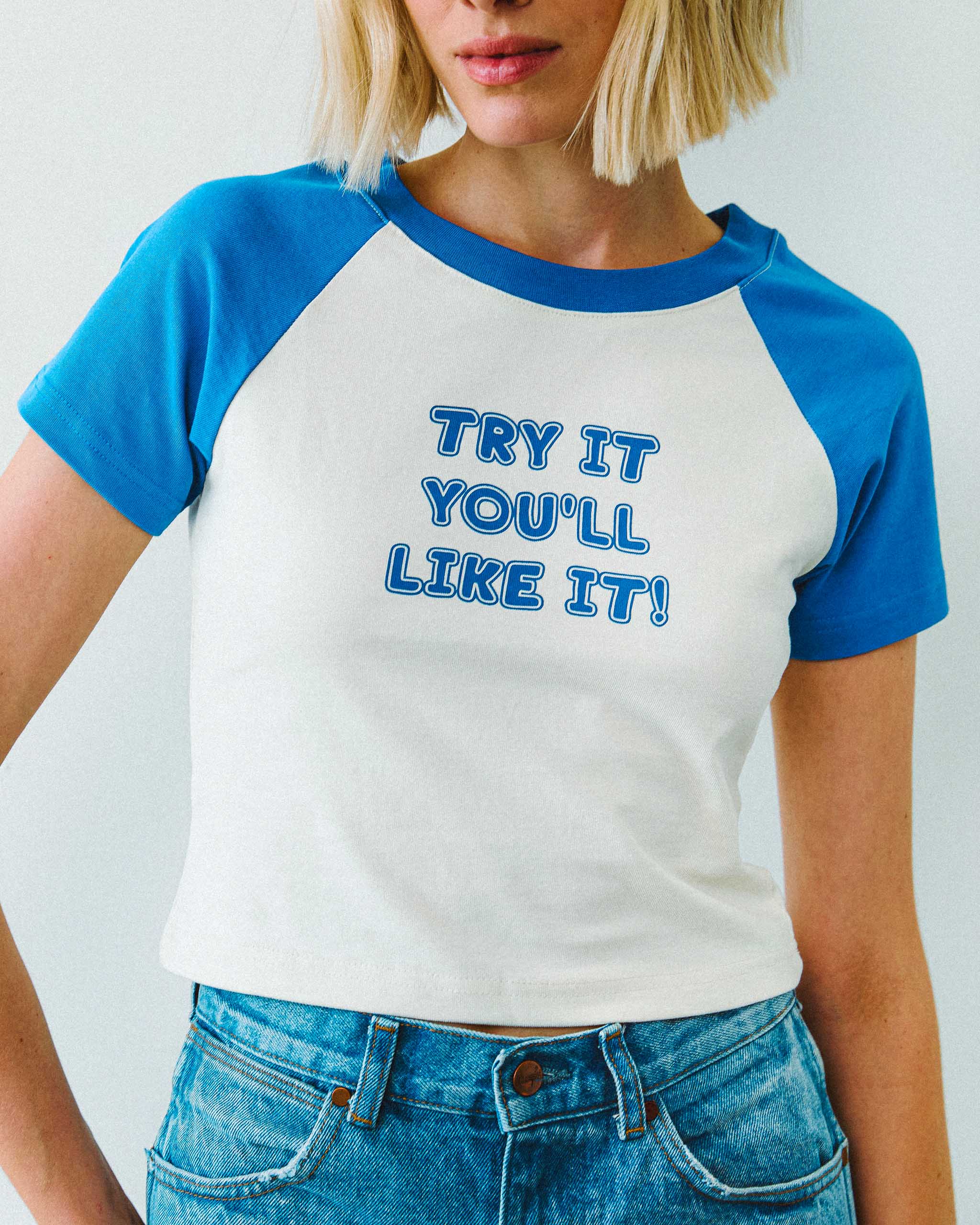 Person wearing a blue and white "Try it you'll like it!" slogan raglan t-shirt, standing against a plain background.