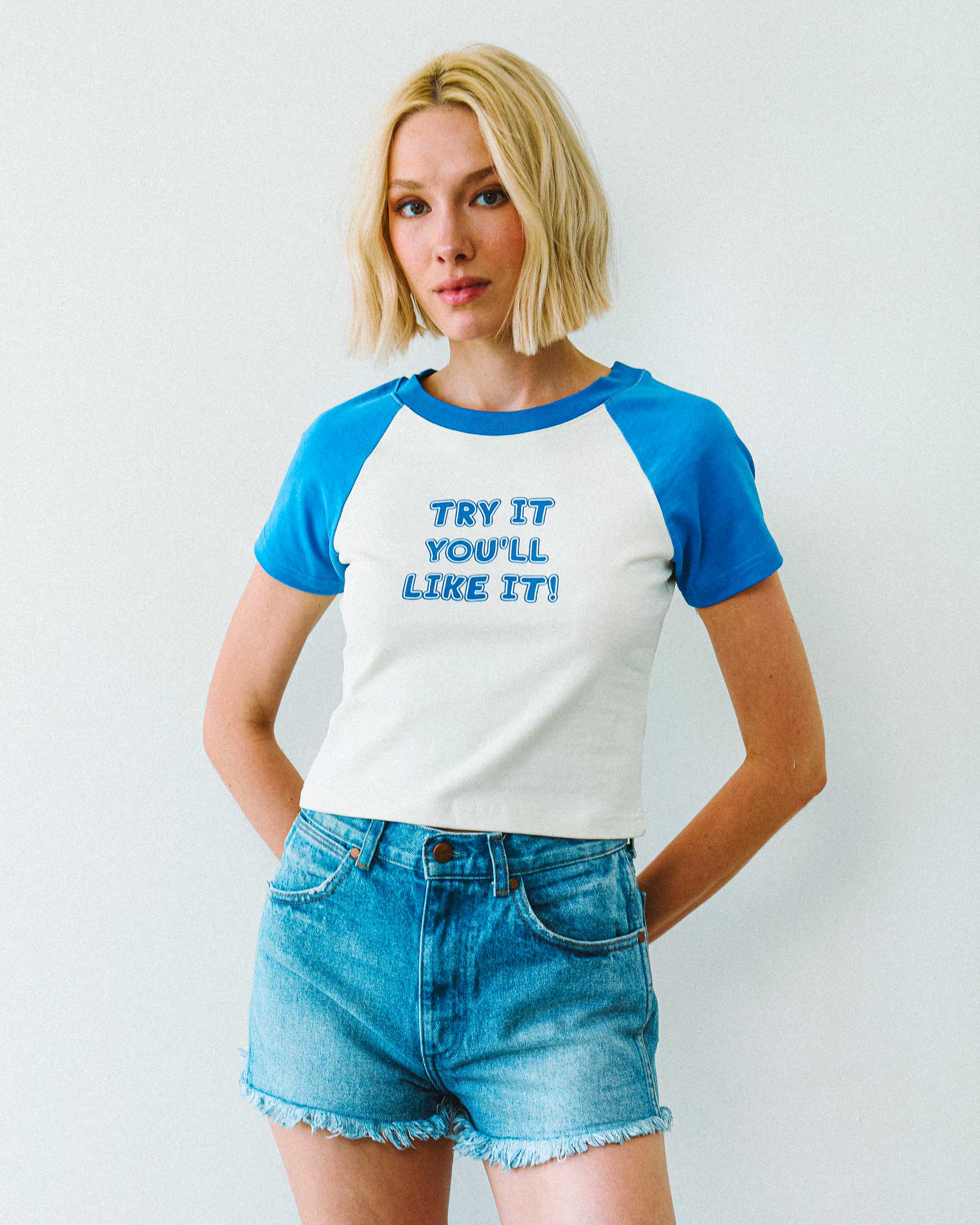 Person wearing a blue and white vintage style "Try it you'll like it!" slogan t-shirt, standing against a plain background.