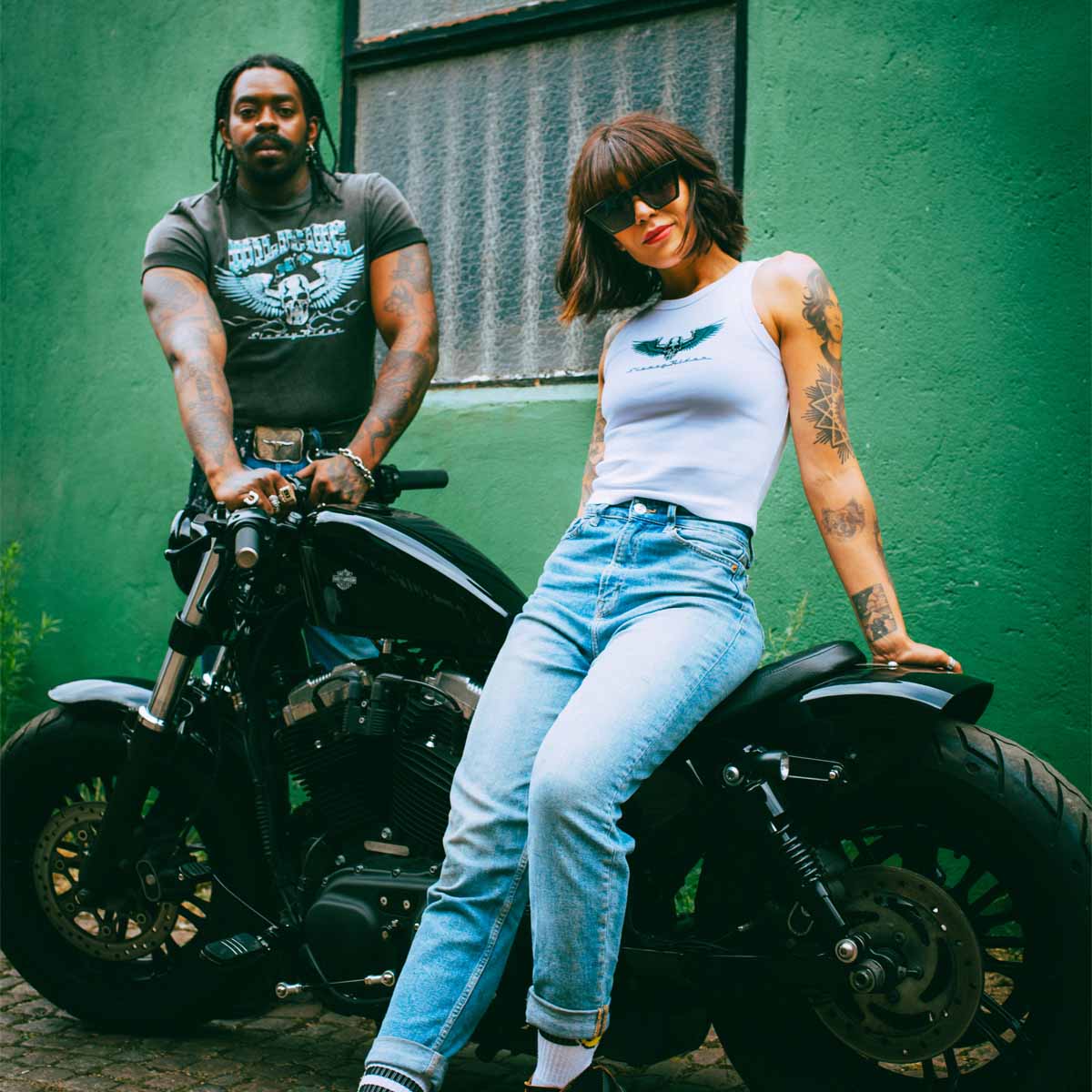 A female biker with a Harley Davidson, wearing a Sleazy Rider tank top.