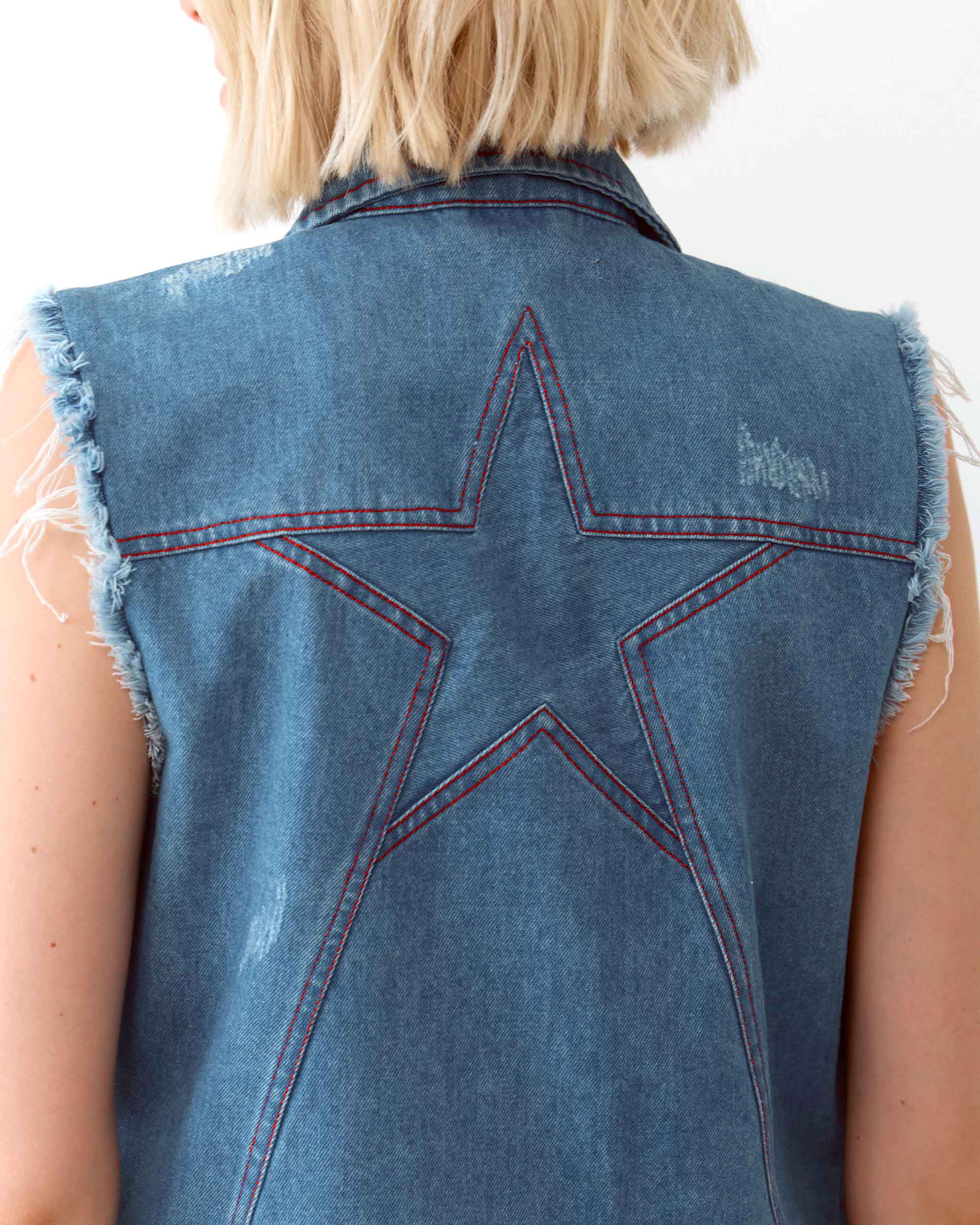 A denim jacket vest with a star panel on the back.