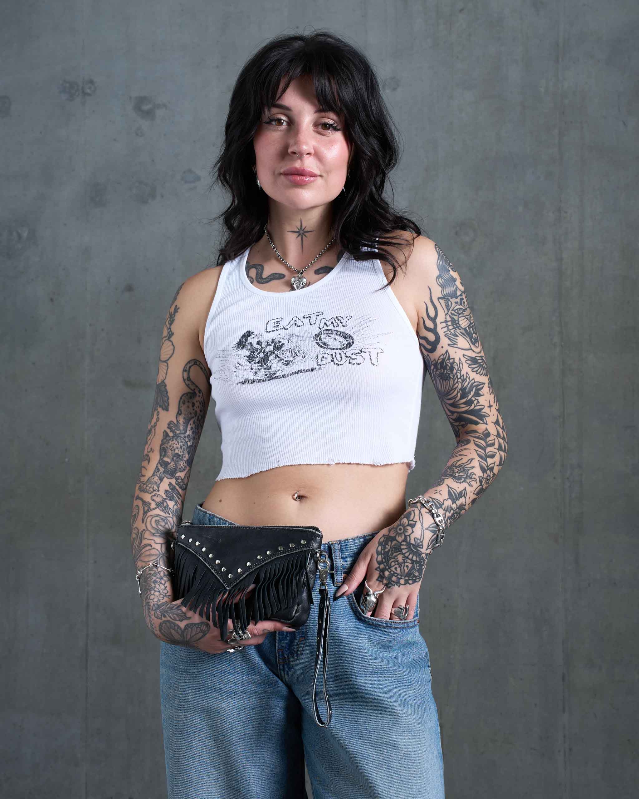 An alternative model holding a dark western mini bag with clutch strap.