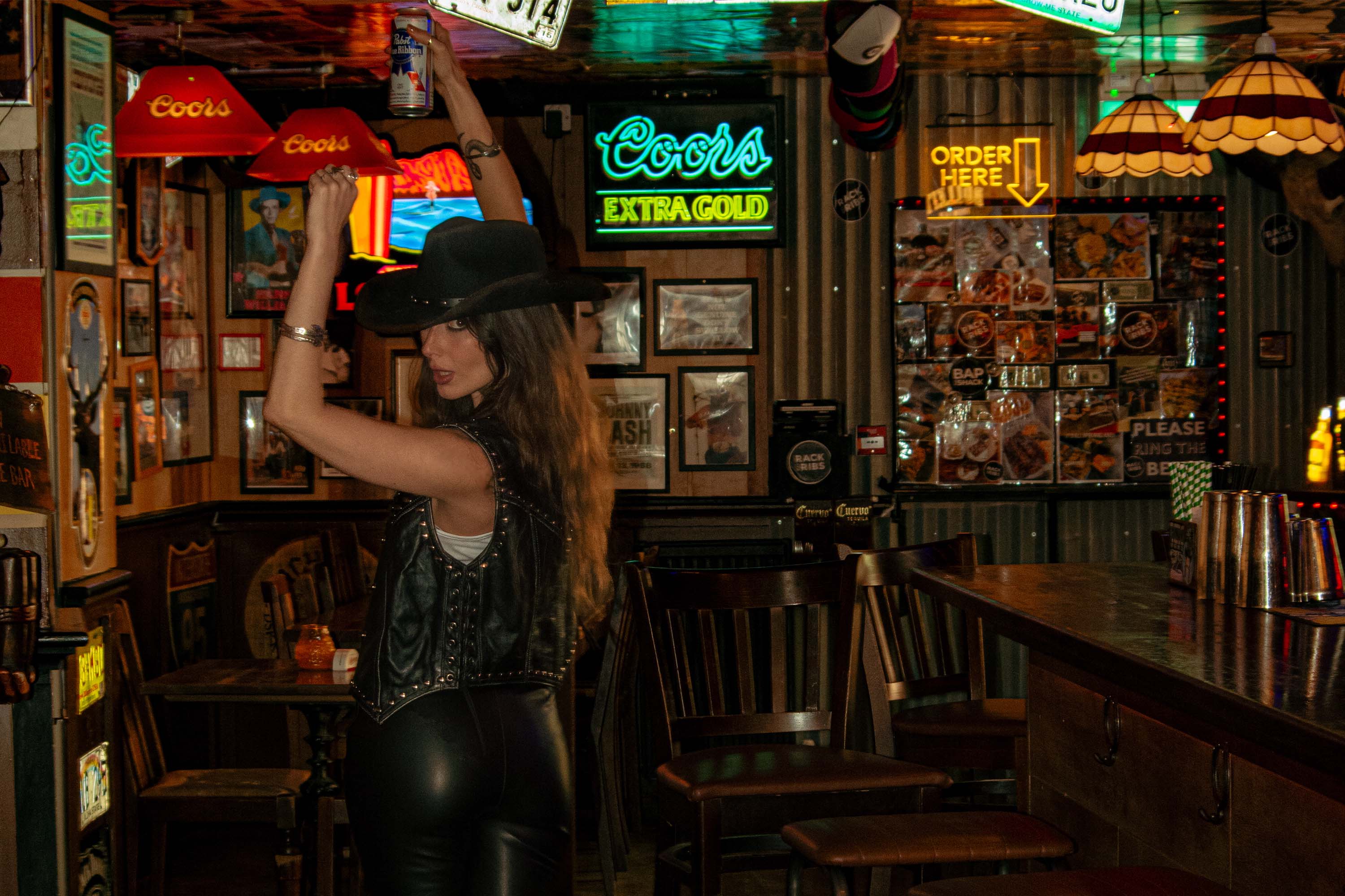 A dark western cowgirl in the Dukes of Highgate dive bar.