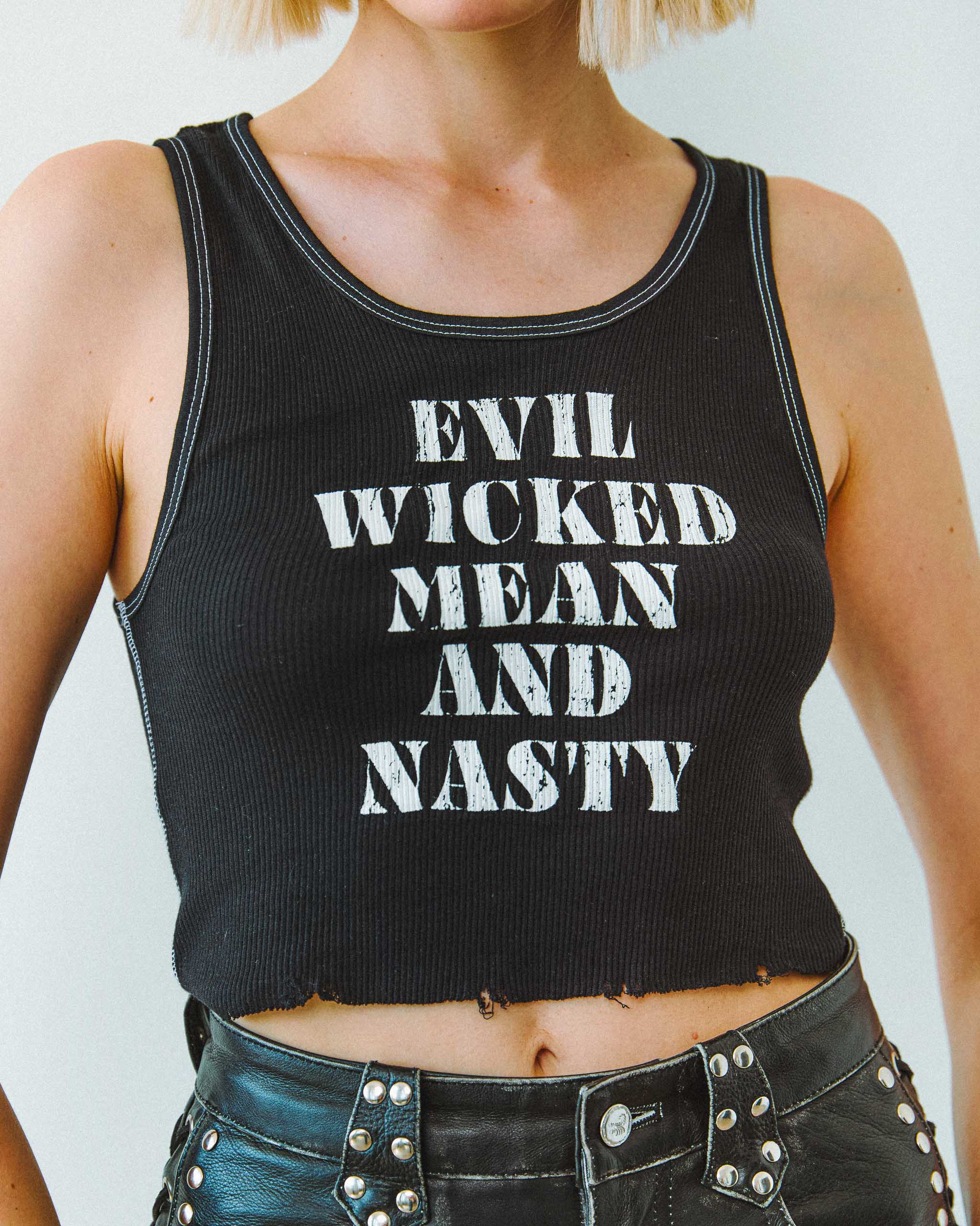 A biker wearing an "Evil Wicked Mean and Nasty" ribbed tank top and studded leather shorts.