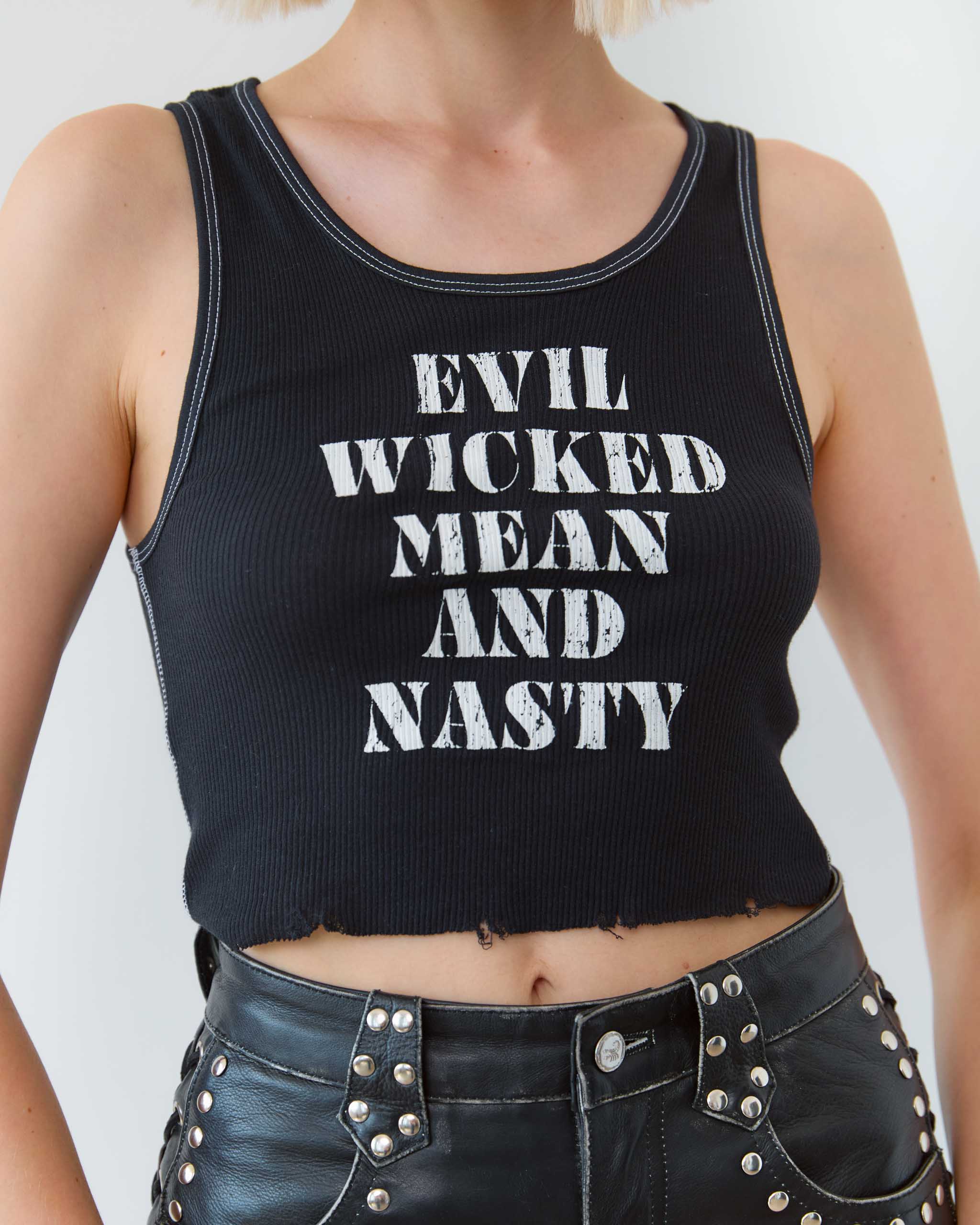 Black tank top with white text 'EVIL WICKED MEAN AND NASTY' worn by a biker woman on a plain background