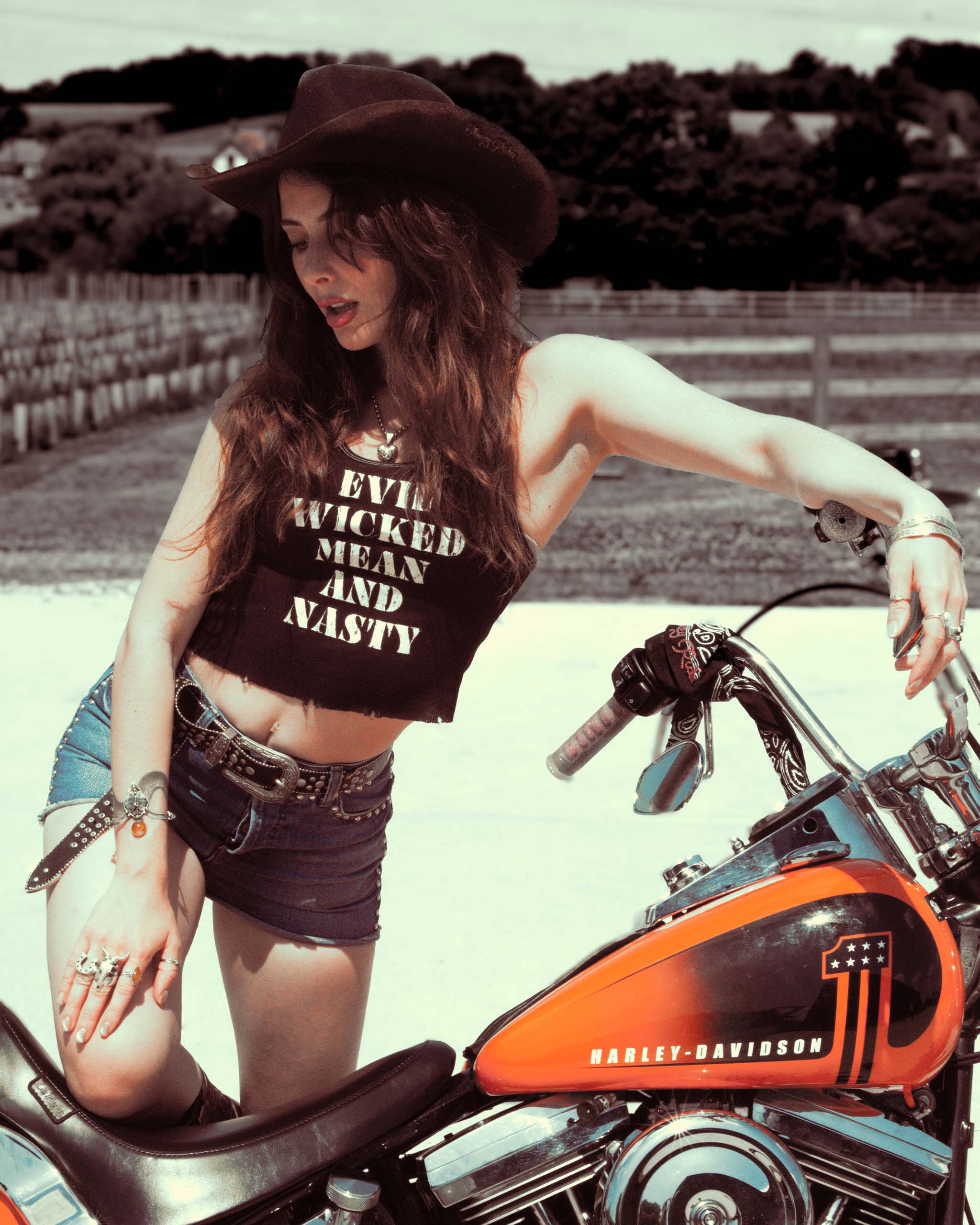 Woman in a gothic western cowboy hat and 'Evil Wicked Mean And Nasty' tank top.