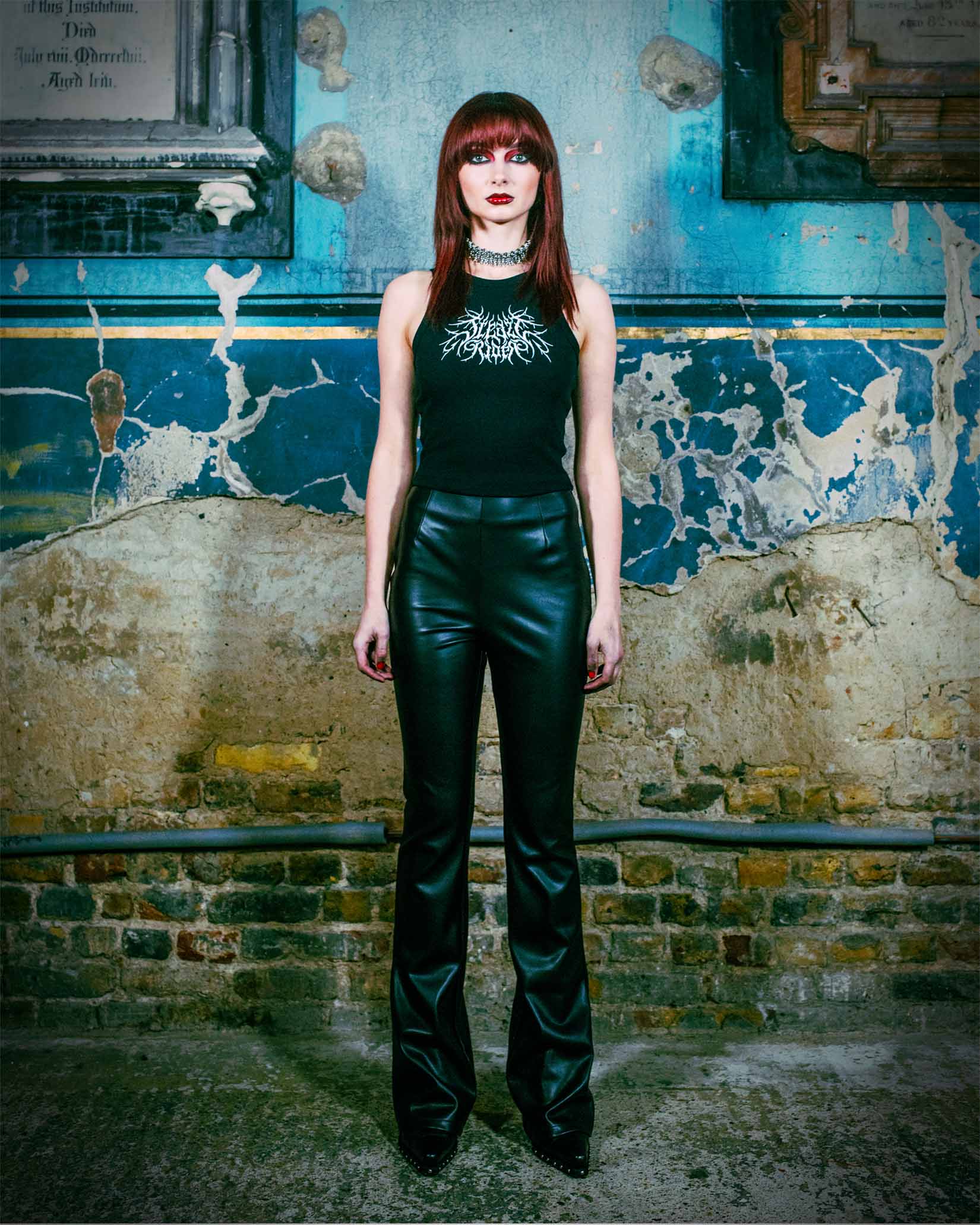 An alternative model wearing a gothic tank top in a church