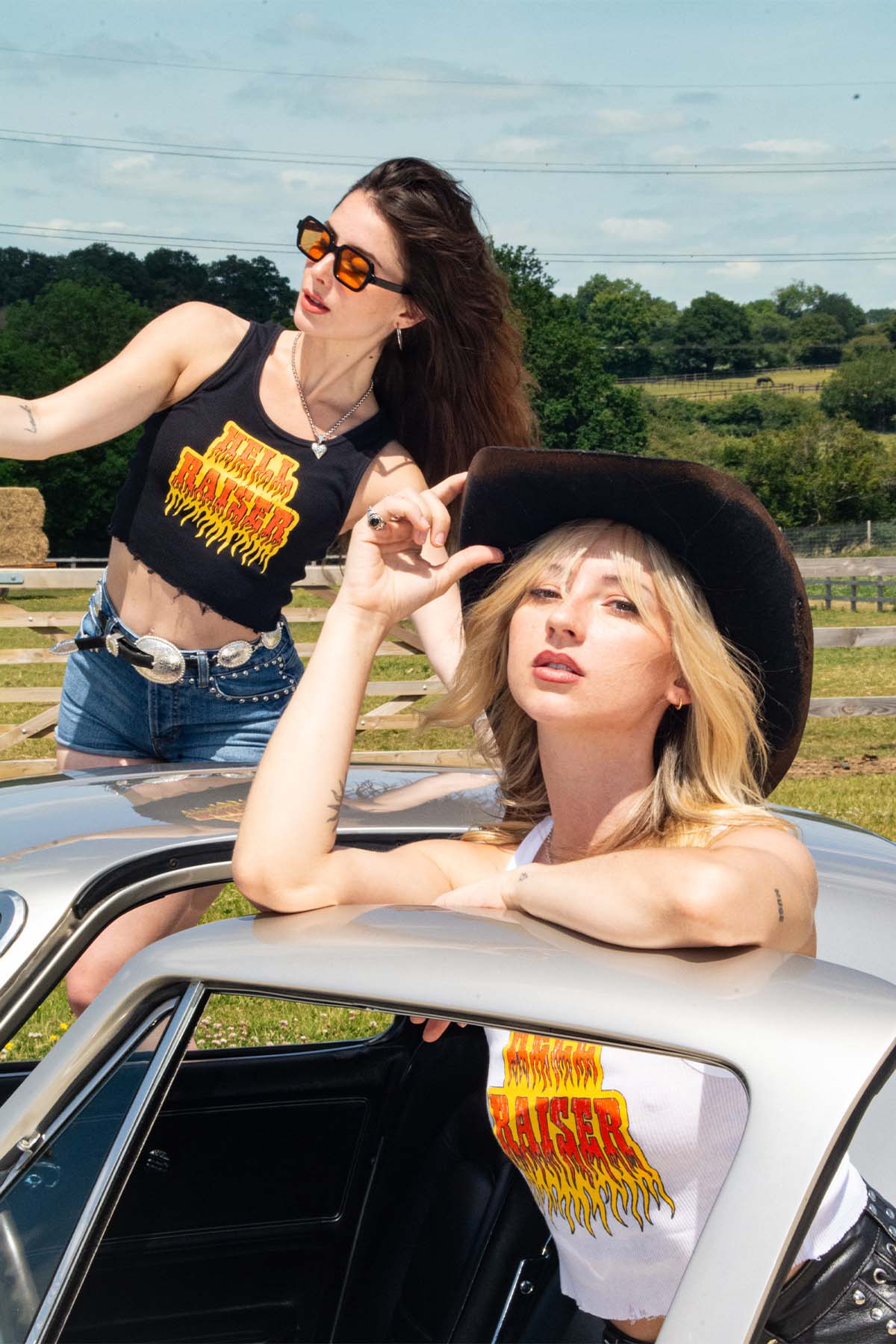 Two women in a vintage car with a scenic background