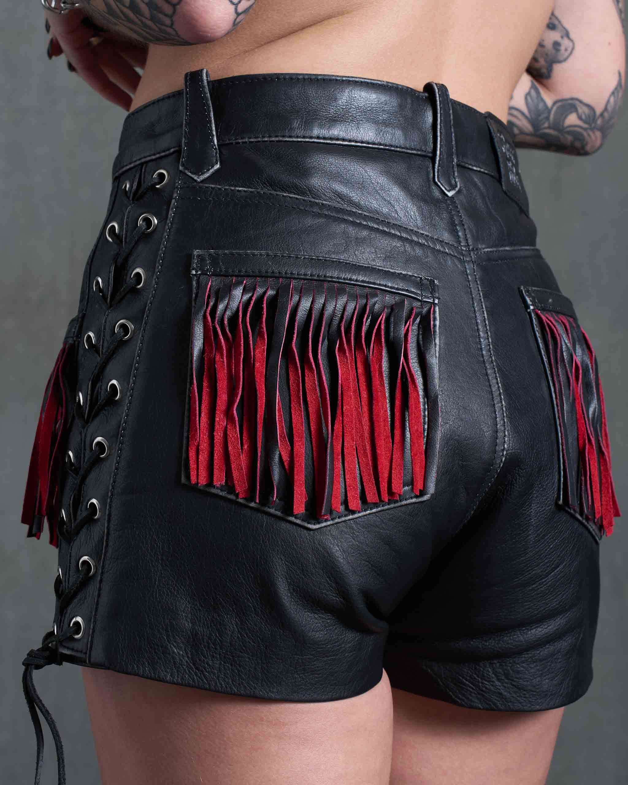Leather biker shorts with red suede fringing on the back pockets.