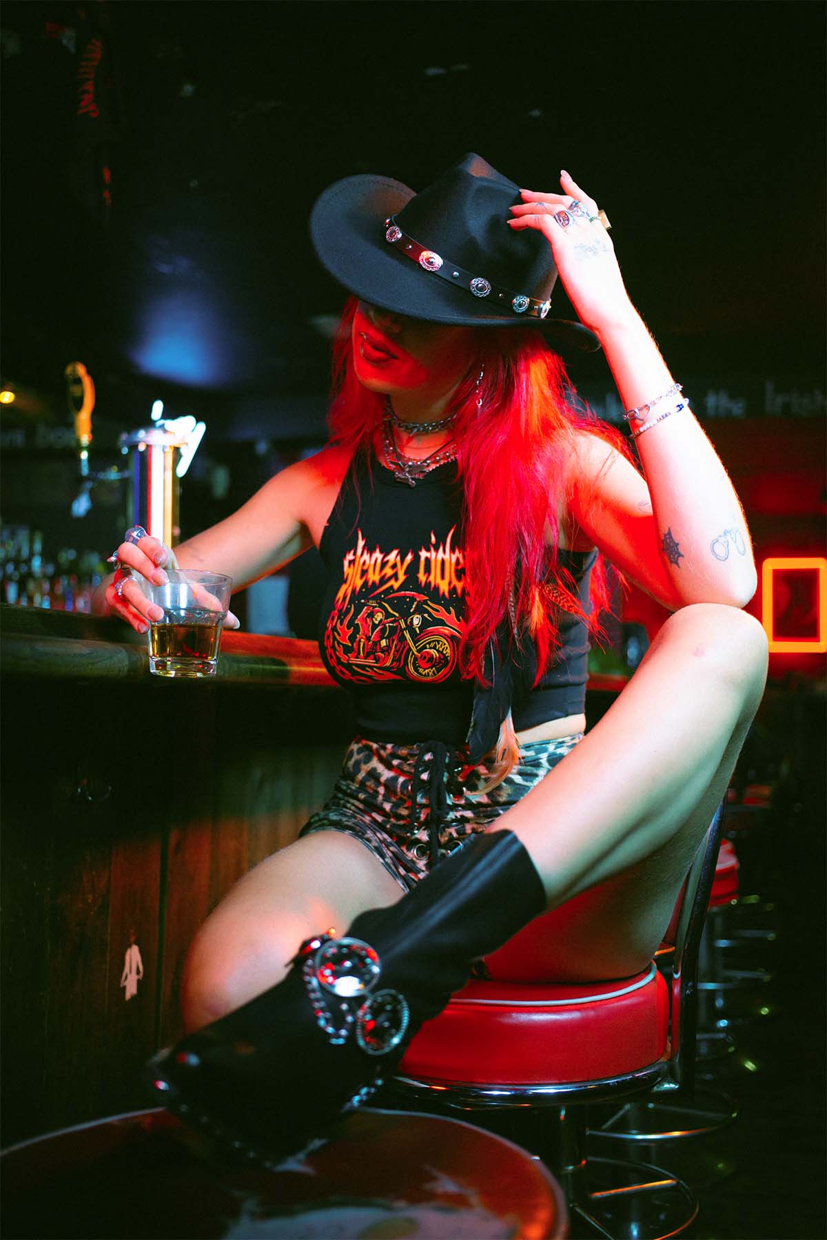 Amy Valentine wearing a Sleazy Rider tank top and western gothic cowboy hat in Slim Jim's London