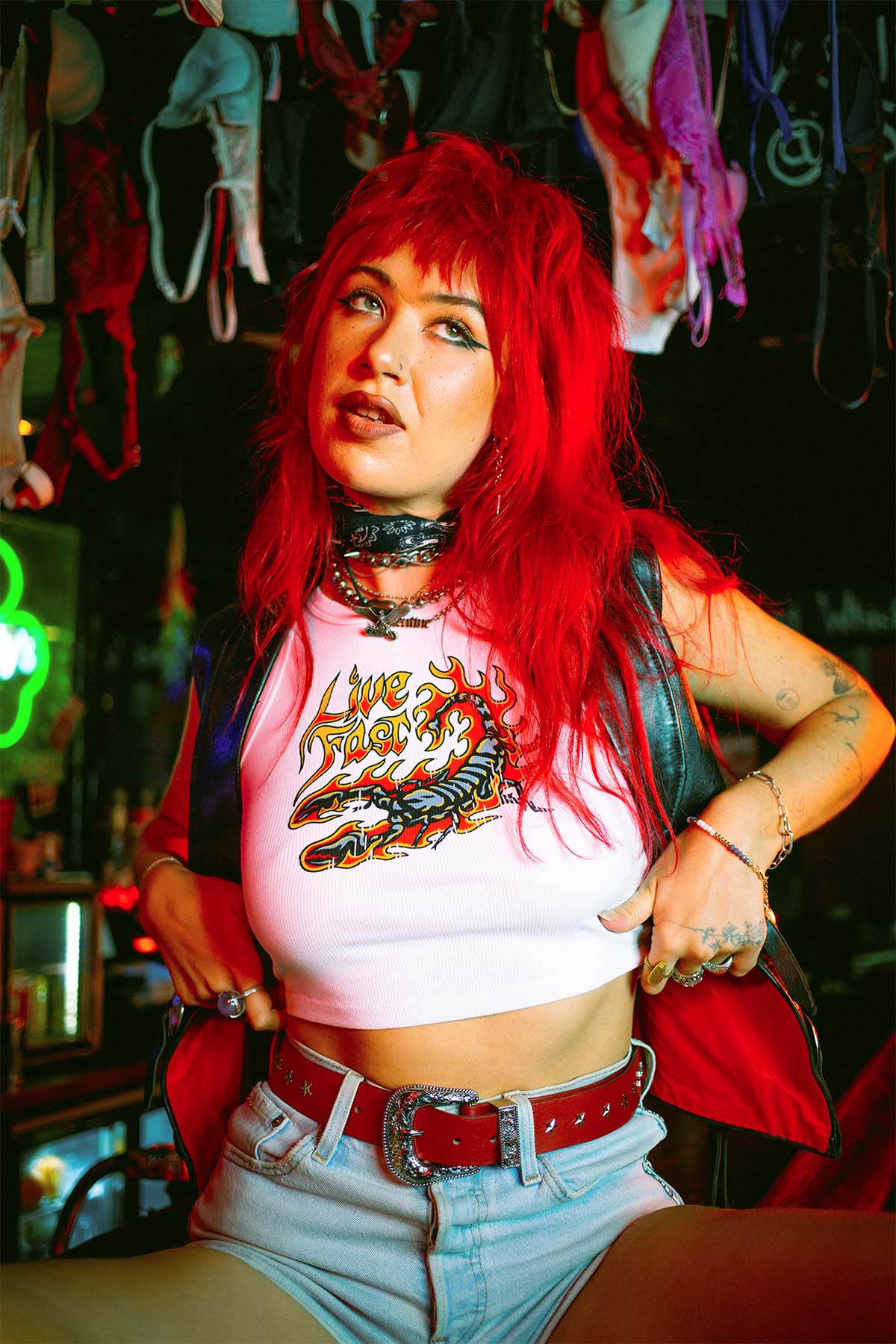 Amy Valentine wearing a Sleazy Rider scorpion tank top in a dive bar
