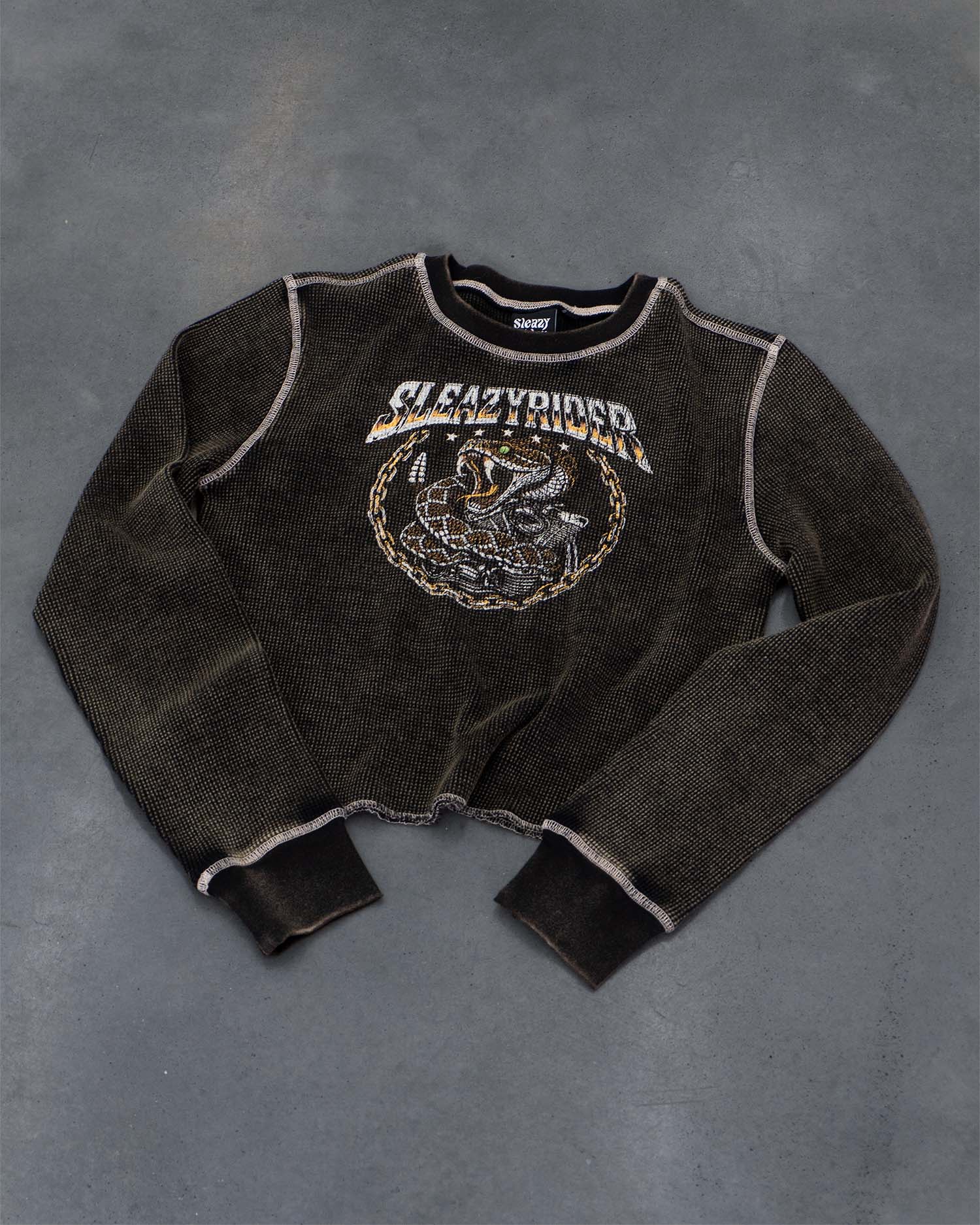A biker waffle knit long sleeve tee with a heavy acid wash, rattlesnake screen print and contrast stitching.