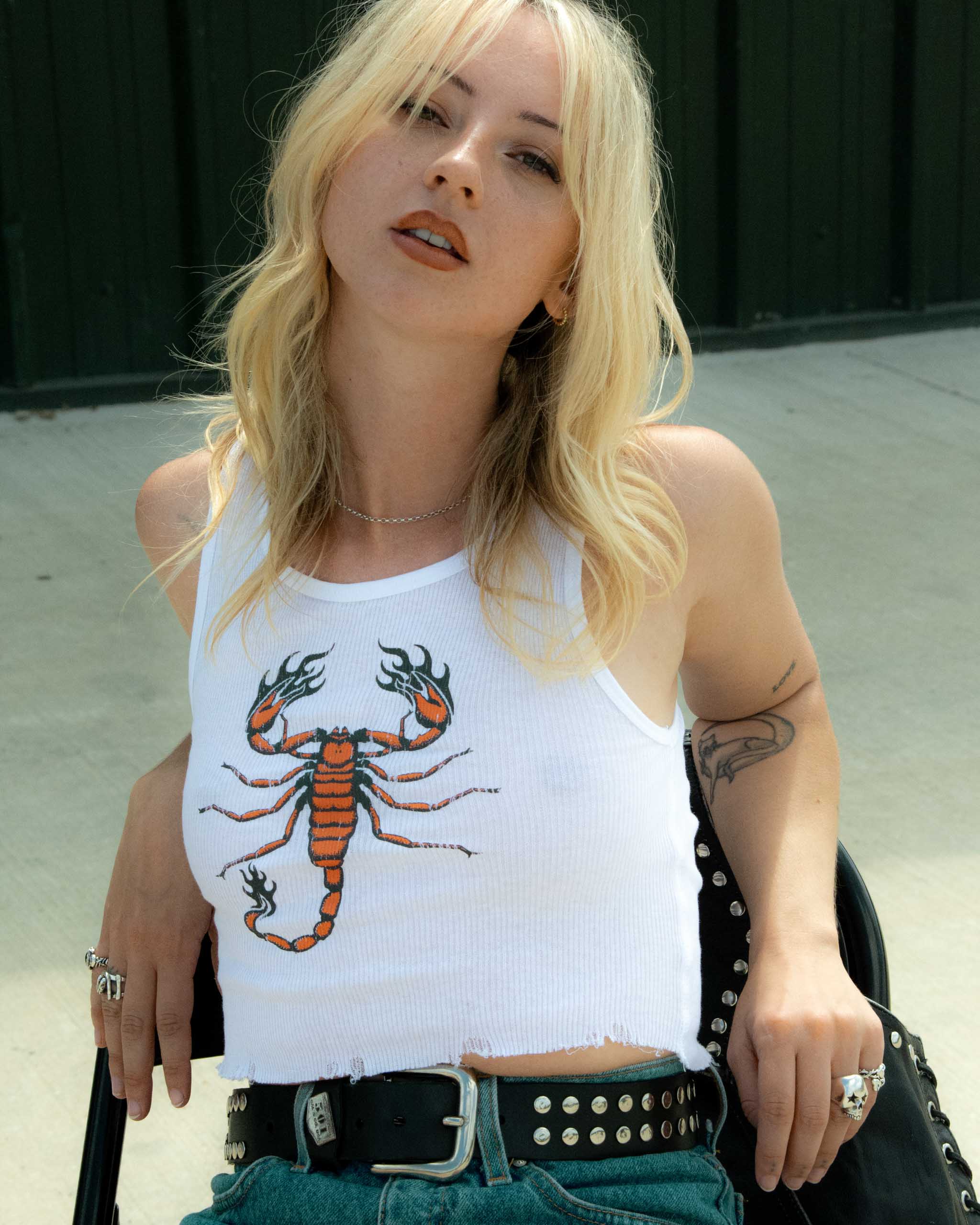 Vintage model wearing a white tank top with a scorpion design.