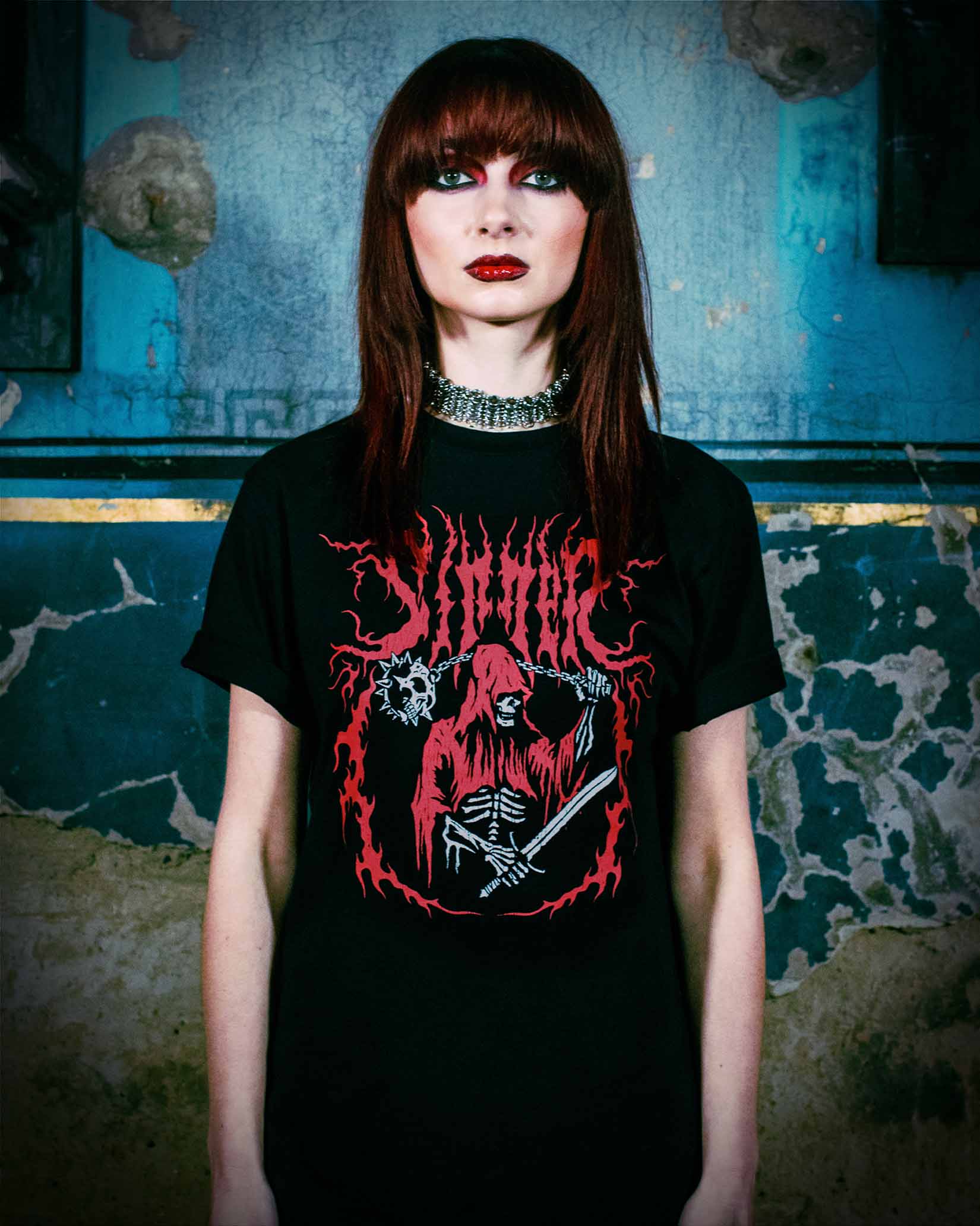 A heavy metal chick wearing a t-shirt with a reaper on the front.