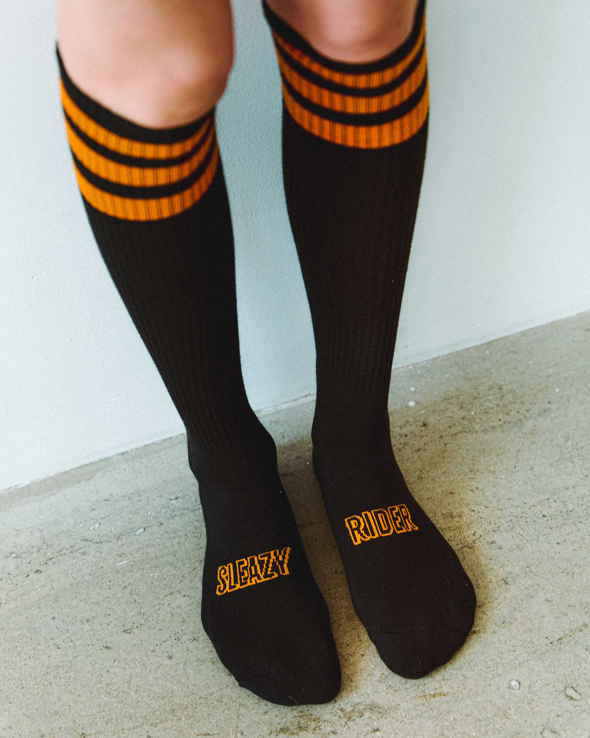 Black and orange knee high Sleazy Rider socks with stripes, in Harley Davidson colours.