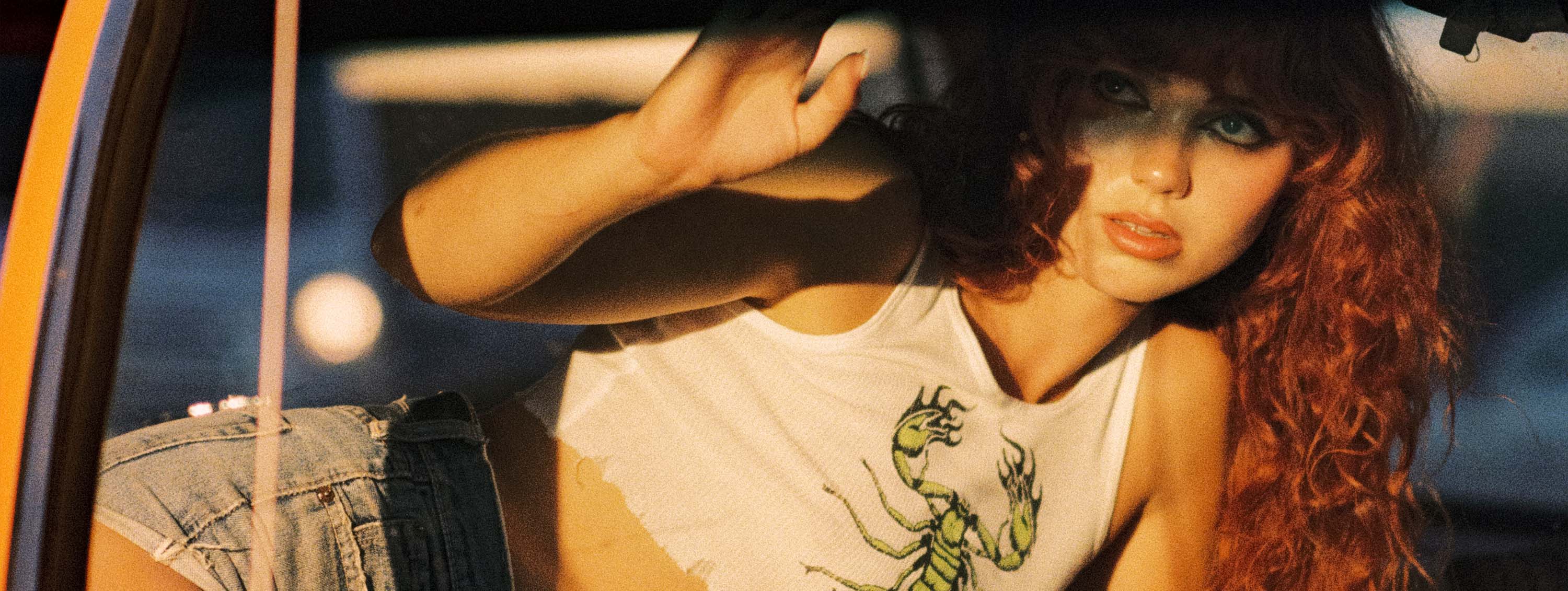 A vintage woman wearing a green scorpion tank top.